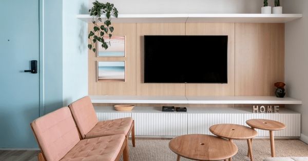 porta-colorida-sala-estar-tons-pasteis-rosa-sofa-azul-painel-televisao-madeira-raque-rack-quadros-decorativos-planta-mesas-centro-branco-decor