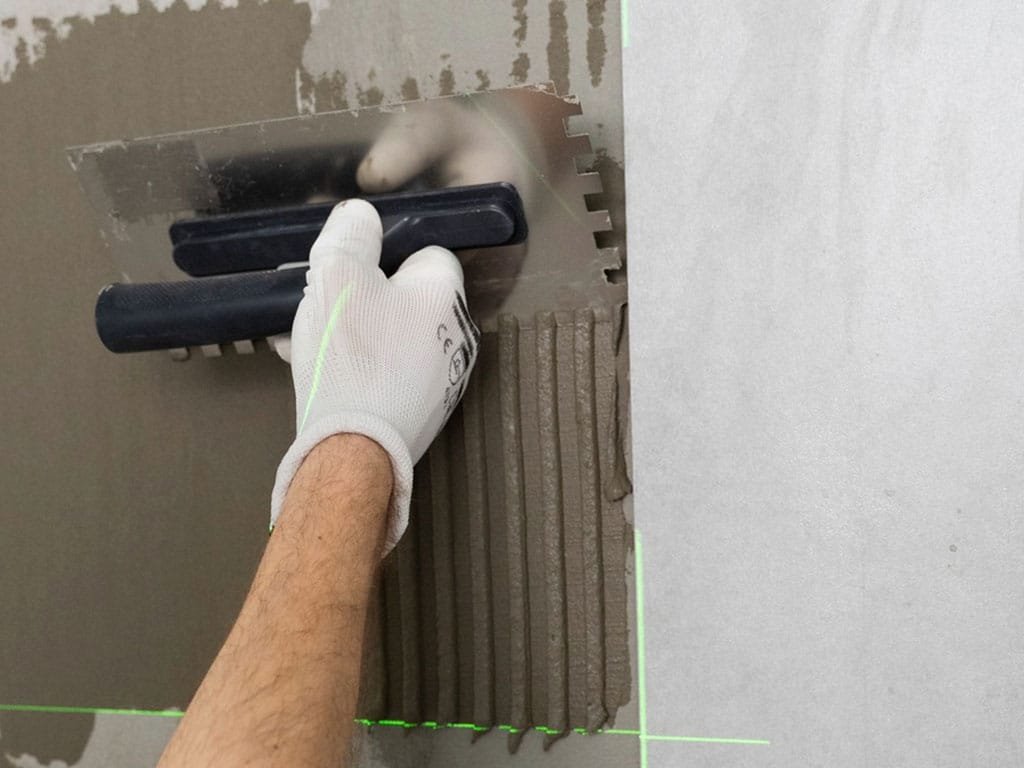 Aplicação de argamassa com desempenadeira.